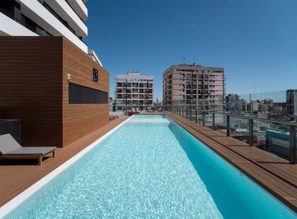 Piscina con solárium en el piso 13 con vistas panorámicas a la ciudad.