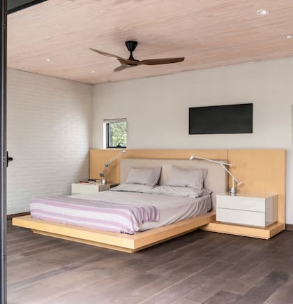 Piso de ingeniería en roble envejecido. Estructura de cama en cohiue diseñada por el Estudio en colaboración con la interiorista chilena María Silva. Mesas de luz laqueadas y respaldo forrado en lino.