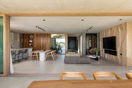 Piso de porcelanato Portobello ‘Berliner’. Del lado izquierdo, la cocina con isla de Neolith ‘Himalaya Crystal’ (De Stefano), trabajada por Mármoles Antón.