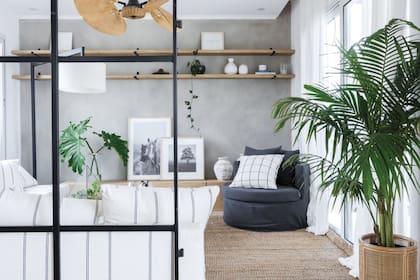 Piso de porcelanato símil madera ‘Oslo’ (Ilva). Sillón en ‘L’, mueble bajo listo para ser apoyo de la tele sin invadir (todo de Sol Palou Deco).