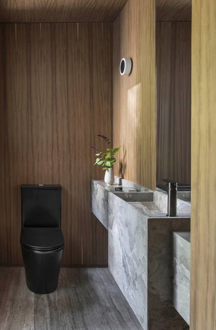 Piso de Travertino, vanitory (Brava Arquitectura) de cuarcita ‘Camouflage’ (Aranda Mármoles) con grifería (Handel). Sanitarios negros (Häusar por DeinHaus).