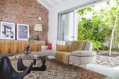 Piso granítico blanco fundido in situ (Tierras Nuestras). Ventanas de aluminio adonizado natural (Alumetal). Mueble vajillero de 1970 restaurado (Carpintería Álvarez). La mesa ratona Noguchi también tienen sus años.