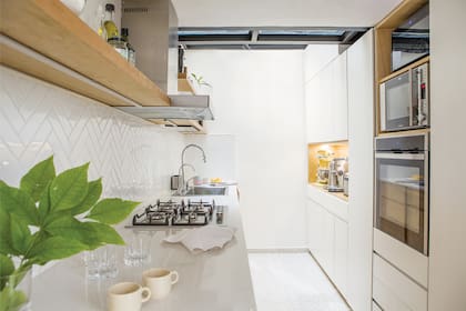 Piso granítico (Moltrasio). Muebles de cocina diseñados por Estudio Yama en MDF laqueado y MDF enchapado en lenga, ejecutados por Mamut Diseño. Mesada de Purastone ‘Blanco Paloma’ (De Stefano). Alzada revestida con azulejos ‘Finlandia Soft’ (Acuarela).