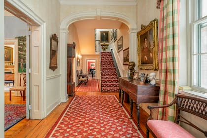 Pisos de madera, carpetas y muebles de estilo en el largo hall de distribución de la casa donde Jackie Kennedy vivió tras el crimen de JFK