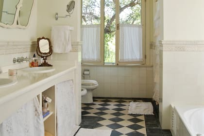 Pisos en damero y espejos de antaño para darle una impronta antigua al baño. ,