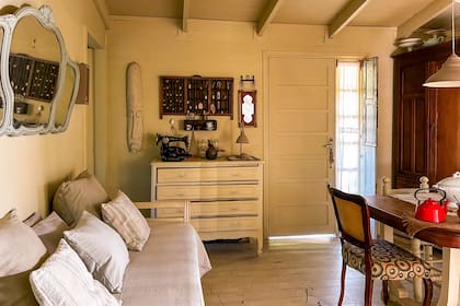 Pisos y paredes de madera hacen un juego perfecto con los muebles comprados en anticuarios en el living comedor.
