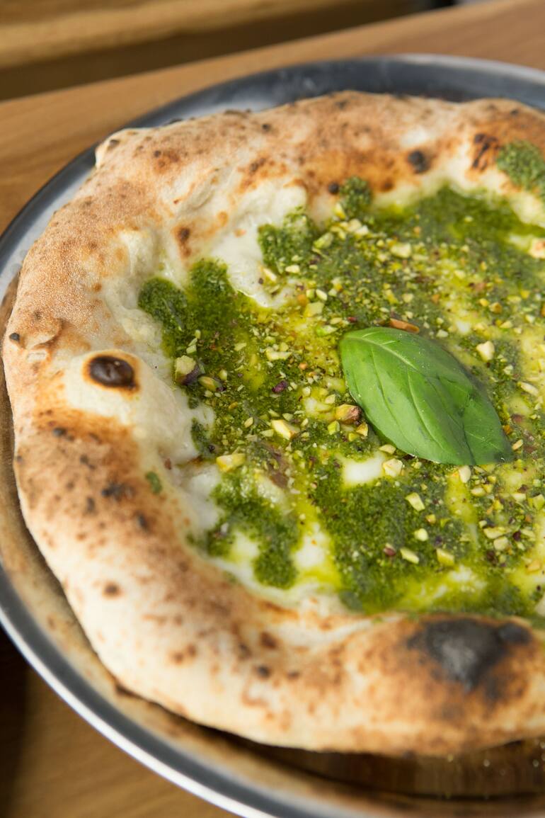 Pizza de queso de cabra, pesto y pistachos en Antonio's.