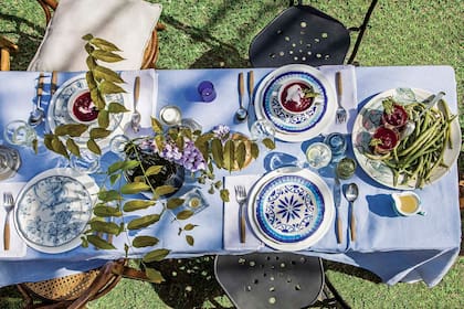 Platos artesanales mezclados con porcelana delicada, juegos que se encuentran. Y una rama blanda y flexible para darle ritmo a todo.