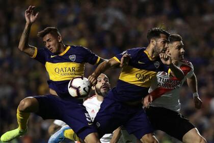 Players of Boca Juniors (Blue and yellow) and River Plate jump for the ball during their all-Argentine Copa Libertadores semi-final second leg football match at La Bombonera stadium in Buenos Aires, on October 22, 2019. (Photo by Alejandro PAGNI / AFP)