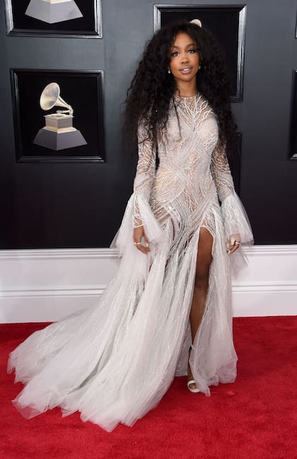 Plumas y gasas vaporosas llevaron a la cantante SZA a otro nivel en este vestido de Atelier Versace; el gris perlado destaca su tono de piel y la parte superior, ceñida, remata en aberturas por las que se puede entrever la piel