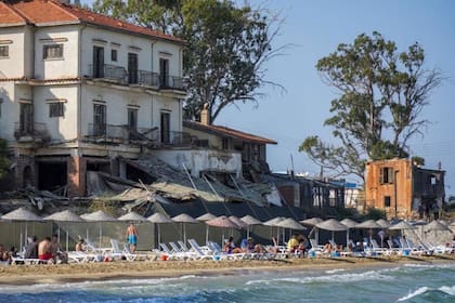 Pocos destinos turísticos ofrecen la posibilidad de bañarse en una playa junto a edificios en ruinas