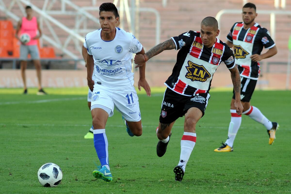 Pol Fernández se lleva la pelota ante la marca de Mellado; el Tomba fue más en el Malvinas Argentinas