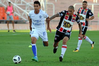 Pol Fernández se lleva la pelota ante la marca de Mellado; el Tomba fue más en el Malvinas Argentinas