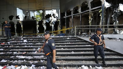 Police officers guard the Congress entrance in Asuncion, Paraguay, Saturday, April 1, 2017. Protesters stormed Paraguay''s Congress building Friday night, setting it on fire after a secret Senate vote to approve a bill that would allow President Horacio Cartes to run for another t