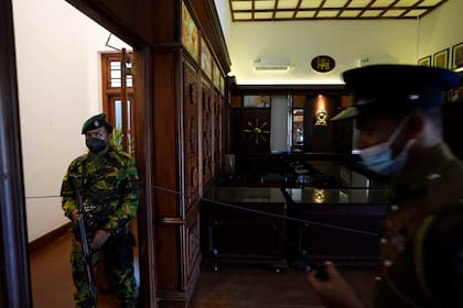 Policía monta guardia en la sala de gabinete de la oficina del primer ministro Ranil Wickremesinghe en Colombo, Sri Lanka, jueves 14 de julio de 2022. (AP Foto/Eranga Jayawardena)