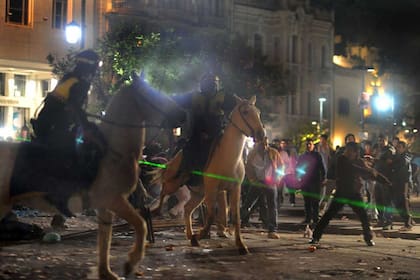 Policía montada arremete contra manifestantes en la plaza Independencia, en la que esta madrugada la gente seguía protestando