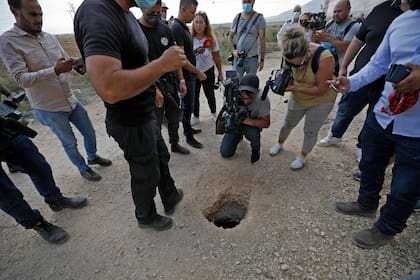 Policía y periodistas rodean el agujero por el que escaparon los seis palestinos