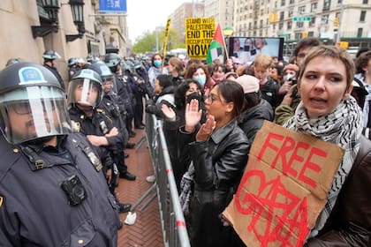 Policías antimotines hacen guardia mientras los manifestantes corean eslóganes en el exterior del campus de la Universidad de Columbia, en Nueva York. (AP Foto/Mary Altaffer, archivo)