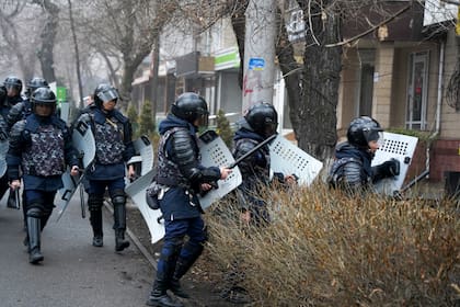 Policías antimotines tratan de cortar el paso a manifestantes durante una protesta en Almaty, Kazajistán