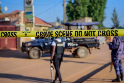 Policías aseguran una calle que lleva a la escena de una explosión en el suburbio de Komamboga, en Kampala, la capital de Uganda, el domingo 24 de octubre de 2021. (AP Foto/Nicholas Bamulanzeki)