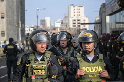 Policías custodian la llegada de la presidenta Dina Boluarte para su declaración, en Lima. (Ernesto BENAVIDES / AFP)