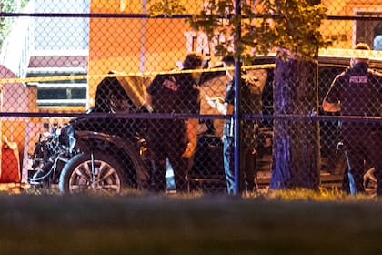 Policías de Vancouver examinan un auto negro sospechoso de haber participado en un atropello contra una multitud en el Festival Lapu Lapu en Vancouver. (Rich Lam/The Canadian Press via AP)