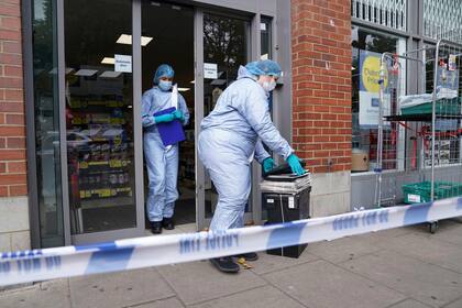 Policías en trajes forenses trabajan en las afueras de un supermercado en el oeste de Londres el 26 de agosto del 2021 en el que un hombre inyecto sangre a varios productos alimenticios. El hombre fue arrestado y compareció en la corte el viernes, 27 de agosto, por cargos de contaminar comida. (Jonathan Brady/PA vía AP)