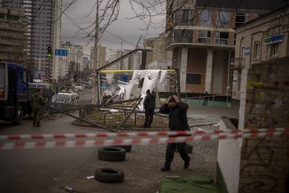 Policías inspeccionan una zona en Kiev, Ucrania, despuÈs de un aparente ataque ruso el jueves 24 de febrero de 2022. (AP Foto/Emilio Morenatti)