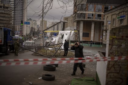 Policías inspeccionan una zona en Kiev, Ucrania, despuÈs de un aparente ataque ruso el jueves 24 de febrero de 2022. (AP Foto/Emilio Morenatti)