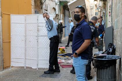 Policías israelíes examinan la escena de un apuñalamiento en el casco viejo de Jerusalén, el jueves 30 de septiembre de 2021. La policía israelí dijo que una supuesta agresora palestina había muerto baleada tras un ataque en la zona antigua de Jerusalén. (AP Foto/Mahmoud Illean)