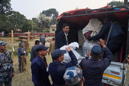 Policías llevan las urnas a un vehículo que las llevará a un centro de conteo tras el cierre de un c