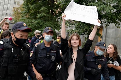 Policías rusos detienen a una periodista que lleva un cartel que dice: "No dejaremos de ser periodistas" en una protesta en Moscú el sábado, 21 de agosto del 2021. (AP Foto/Denis Kaminev)