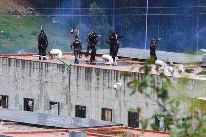 Policías toman sus posiciones en el techo de la prisión de Turi después de un motín el domingo 3 de abril de 2022, en Cuenca, Ecuador. (AP Foto/Marcelo Suquilanda)