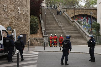 Policías y personal de emergencias esperan instrucciones afuera del consulado iraní en París, el viernes 19 de abril de 2024. (AP Foto/Thomas Padilla)