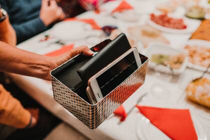 Poner los celulares en una caja, o apilarlos, es una forma de acordar entre todos no usarlos durante la cena