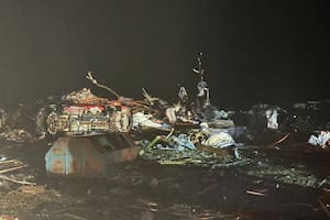 Por la calle yacen escombros, automóviles que volcaron y pedazos de propiedades como efectos de los tornados en Estados Unidos