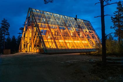 Por la noche, la casa ilumína con energía solar los arbustos más allá de su perímetro.