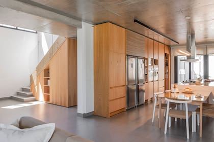 Por sus características, la madera necesita de mucho mantenimiento en exteriores, de ahí que el pedido de que solo usara puertas adentro. La mesa y las sillas de la cocina son de Marini Estudio.