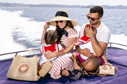 Postal familiar. Camila, con sombrero de ala ancha y canasto de Louis Vuitton, comparte una travesía en barco junto a su marido, Juan Carlos, y sus hijas, Aurora y Alma, que lucen looks marineros idénticos y mini carteras LV, iguales a las de su mamá
