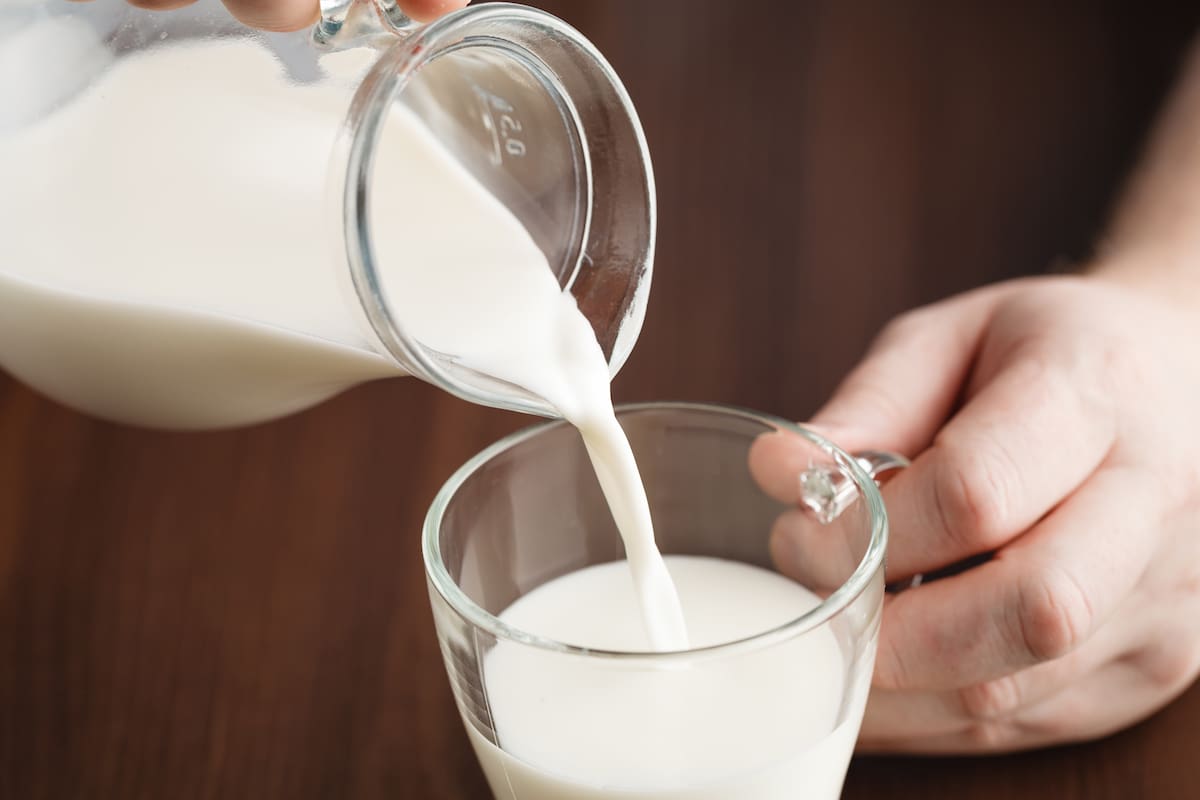 Pouring milk into glass, close up view