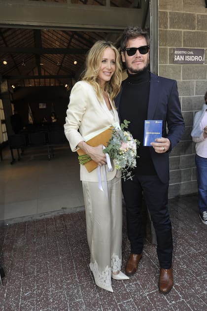 Prandi y Ortega posaron juntos: ella eligió un traje de seda en tono claro, maquillaje natural, pelo suelto, un ramo hecho especialmente y aros azules; él optó por un traje oscuro