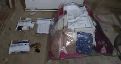 Prendas, objetos personales y teléfonos celulares incautados por los investigadores, embalados para su análisis pericial