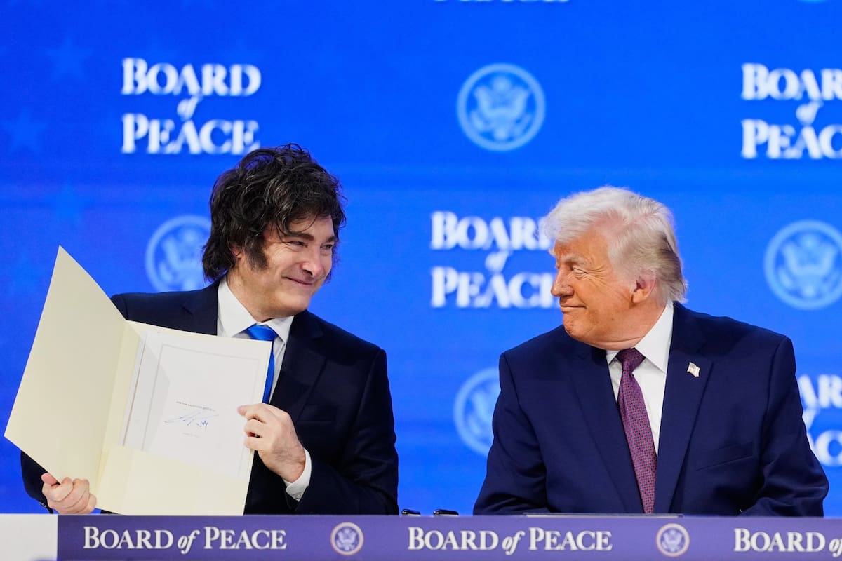 President Donald Trump watches President of Argentina Javier Milei during a signing ceremony on his Board of Peace initiative at the Annual Meeting of the World Economic Forum in Davos, Switzerland, Thursday, Jan. 22, 2026. (AP Photo/Markus Schreiber)