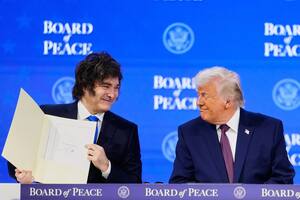 President Donald Trump watches President of Argentina Javier Milei during a signing ceremony on his Board of Peace initiative at the Annual Meeting of the World Economic Forum in Davos, Switzerland, Thursday, Jan. 22, 2026. (AP Photo/Markus Schreiber)