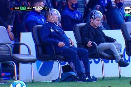 Maradona apareció con una máscara en el amistoso entre San Lorenzo y Gimnasia; a su lado, su hijo Diego Fernando