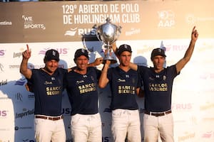Primera vez que Poroto Cambiaso sostiene un trofeo de Triple Corona en un podio; a su derecha, su papá, Adolfo, que cumplió otro anhelo en su trayectoria deportiva, y en los extremos, David Stirling y Juan Martín Nero: La Dolfina es el campeón del Abierto de Hurlingham.