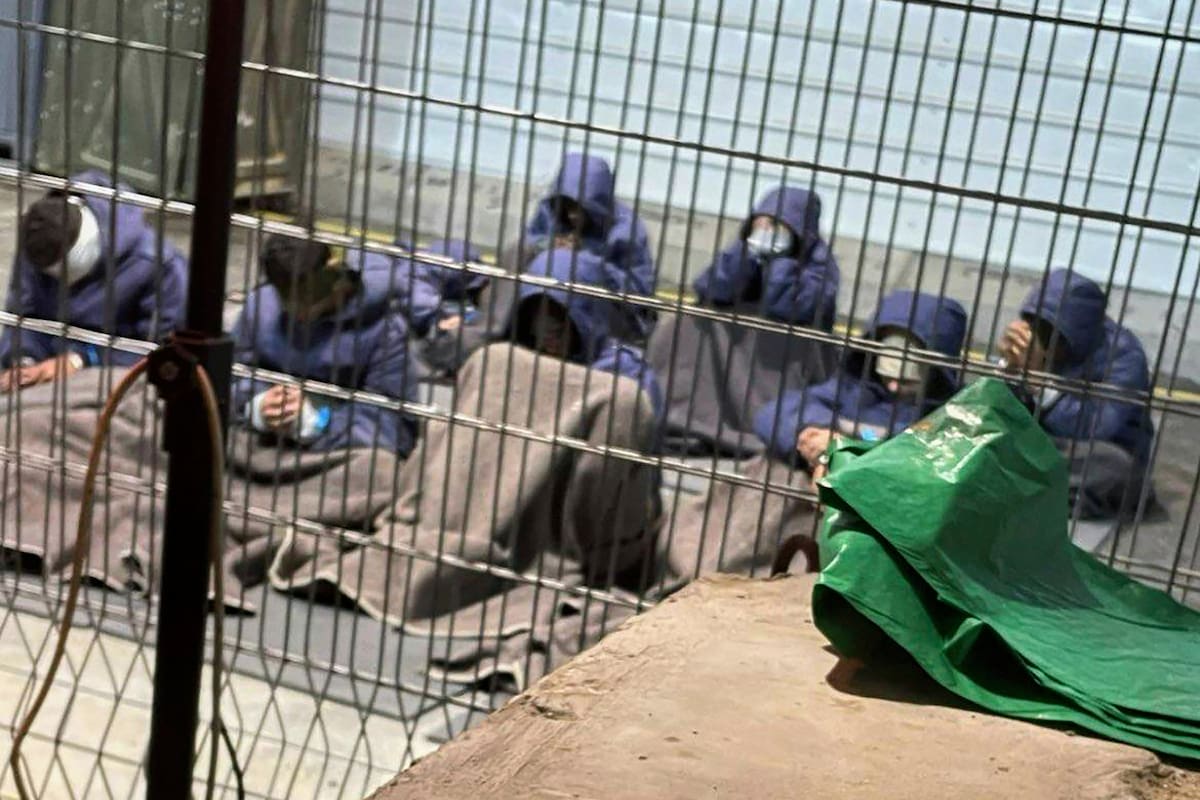 Prisioneros con las manos y las piernas atadas en el patio de la prisión militar de Sde Teiman, en el sur de Israel.