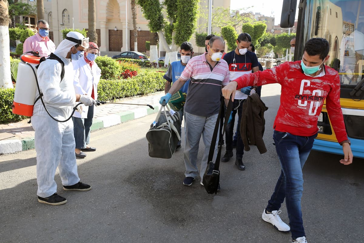 Profesores y estudiantes son desinfectados al ingresar en la Universidad de El Cairo, en Egipto