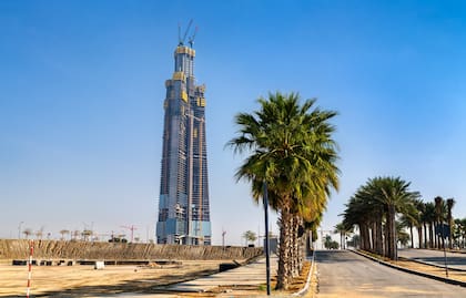 Progreso de la construcción de la Torre Jeddah, que será el edificio más alto del mundo, visto desde una carretera bordeada de palmeras en el distrito de Abhur