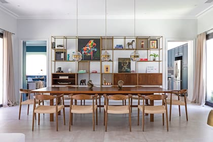 Protagonista y leit motiv del comedor, la biblioteca metálica llegó desde Chile. Mesa de madera (ambas, Broca, Chile) y sillas ‘Norfolk Attimo’ (Tienda Paris, Chile).